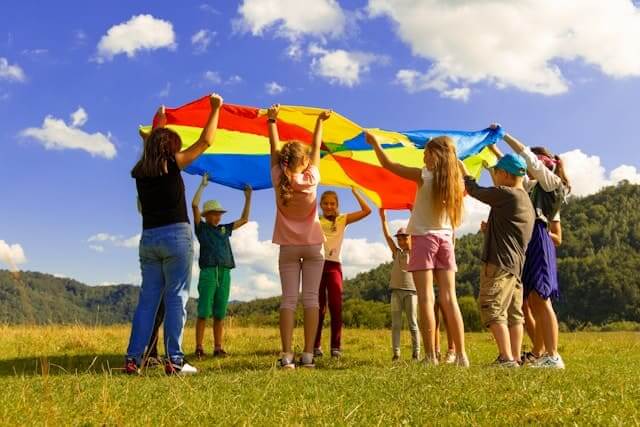 Sozialpädagogin leitet Kindergruppenspiel im Freien